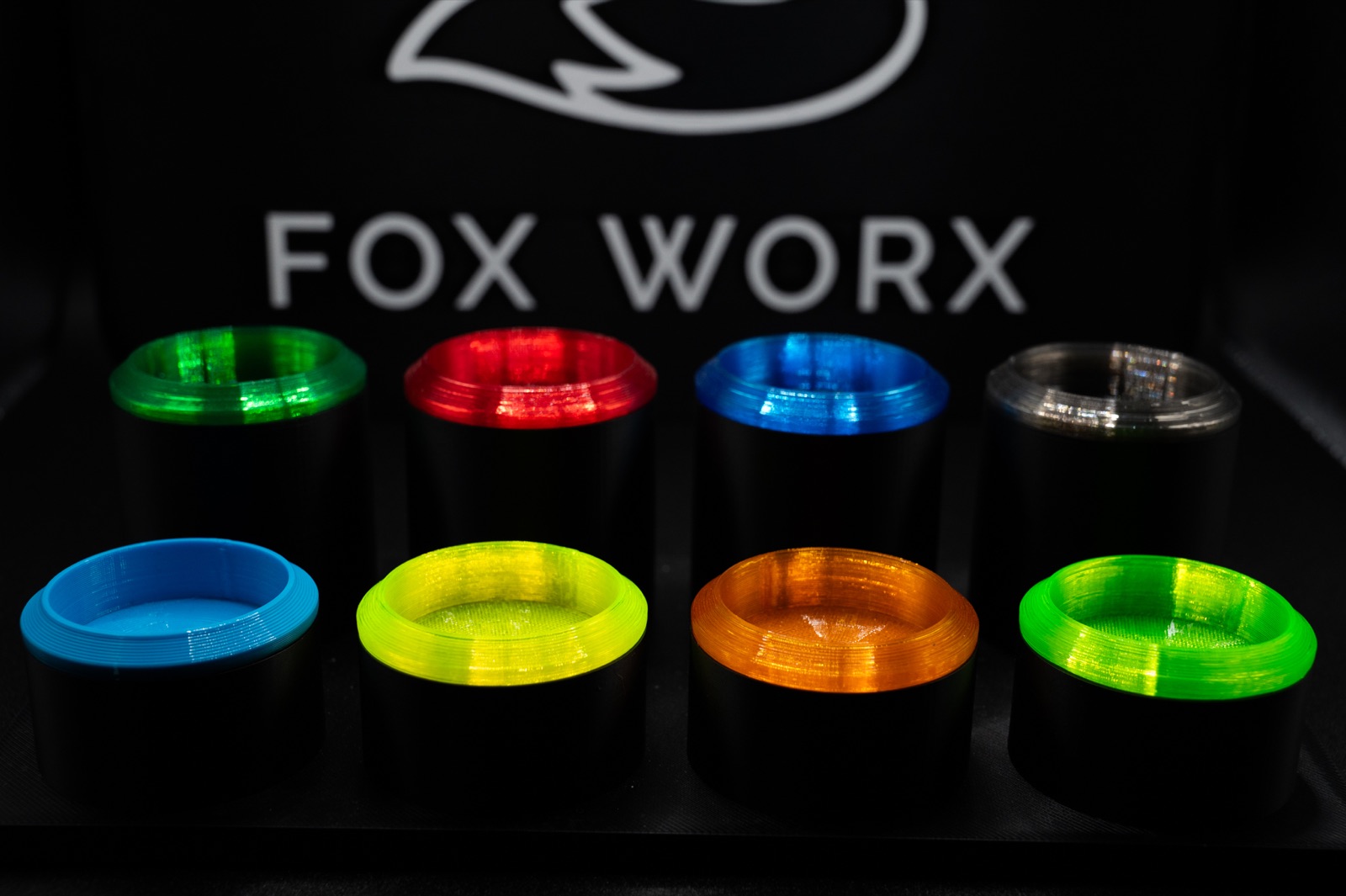 Close-up of Fox Worx pole bungs in multiple colours against the Fox Worx logo